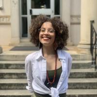 The image shows a curly hair woman smiling.